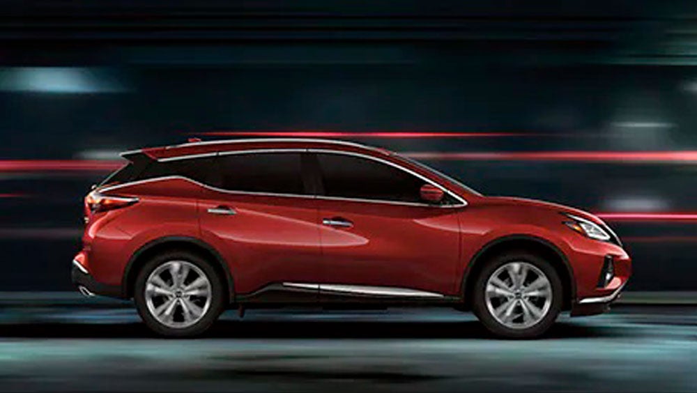 2023 Nissan Murano shown in profile driving down a street at night illustrating performance. | Nissan of Melbourne in Melbourne FL